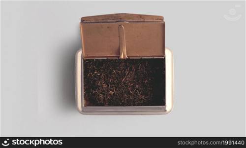 Raw tobacco in a box against white background.top up view