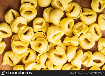 Raw Tortellini on the wooden board, prepared for cooking