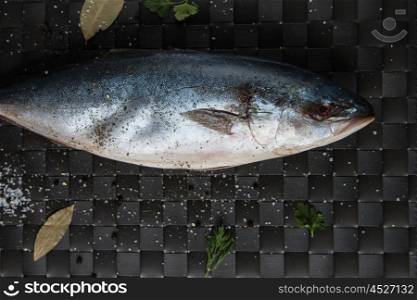 raw tuna fish. raw tuna fish with salt and spices on black background