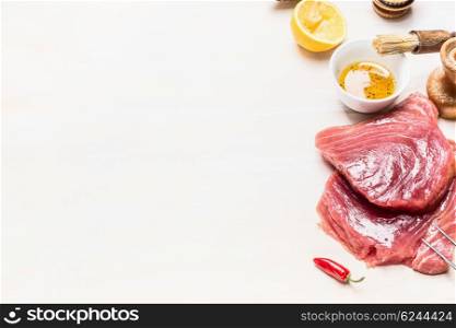 Raw tuna meat and ingredients for grill or cooking on white wooden background, place for text