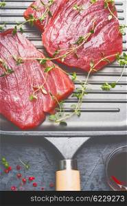 Raw Tuna Steaks in grill frying pan with herbs , top view, close up