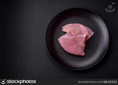 Raw turkey meat in the form of slices with sa<, sπces and herbs on a dark concrete background