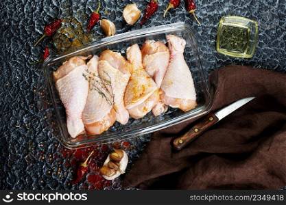 Raw uncooked chicken legs with ingredients for cooking