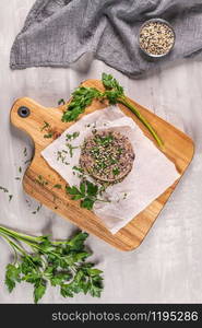 Raw veggie burger with black beans on wood countertop