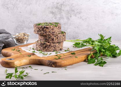 Raw veggie burger with black beans on wood countertop