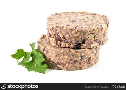 Raw veggie burger with black beans with parsley leaves on white background.