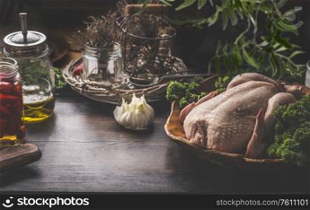 Raw whole chicken on dark rustic background with ingredients for tasty home cooking. Preparation and chicken marinating with lemon, honey and mustard. Home cuisine. Chicken soup or broth cooking