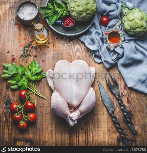 Raw whole chicken with vegetables and ingredients on wooden kitchen table for tasty cooking, top view