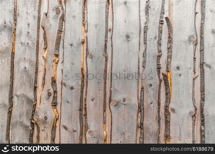 Raw wood background with grey planks with bark