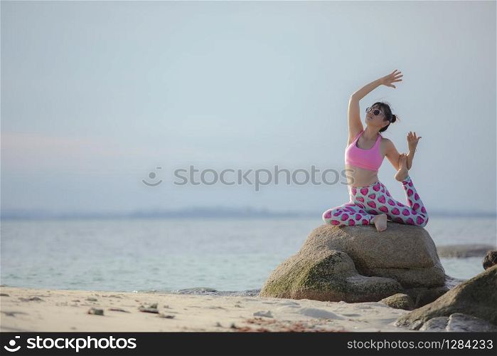 RAYONG THAILAND - MAY2,2018 : three asian woman playing yoga on sea beach ,yoga is popular trend for modern lifestyle people in thailand