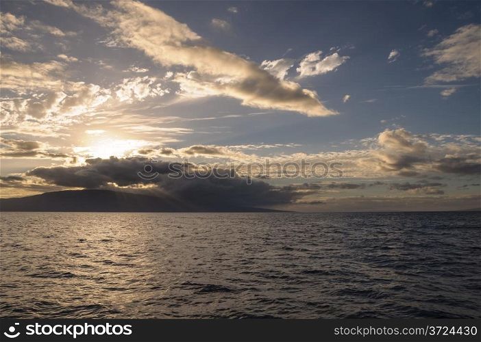 Rays of light come through the clouds as the sun begins to set over the Hawaiian island of Lana&rsquo;i.