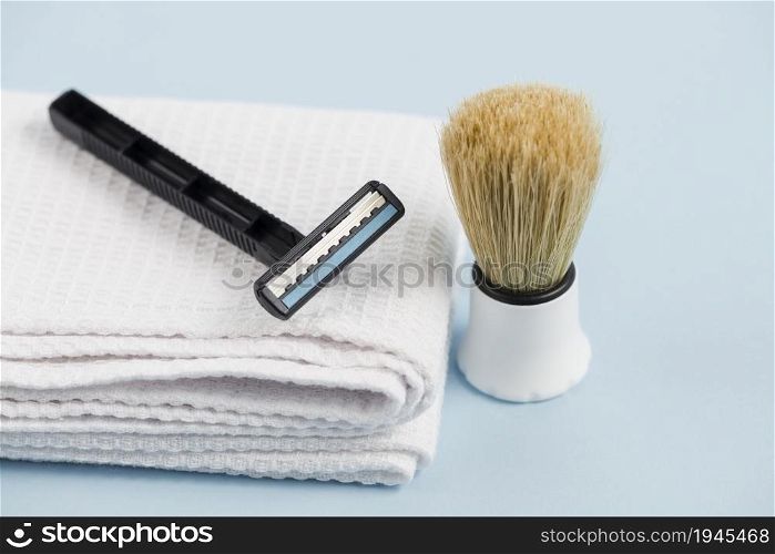 razor white folded napkin classic shaving brush against blue background. High resolution photo. razor white folded napkin classic shaving brush against blue background. High quality photo