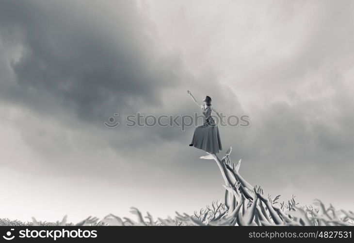 Reaching out. Young woman in evening dress walking on hands of crowd of people