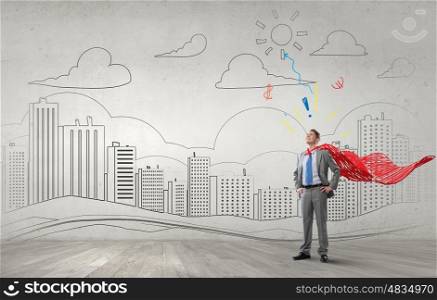 Reaching top of success. Young confident super businessman with cape behind back