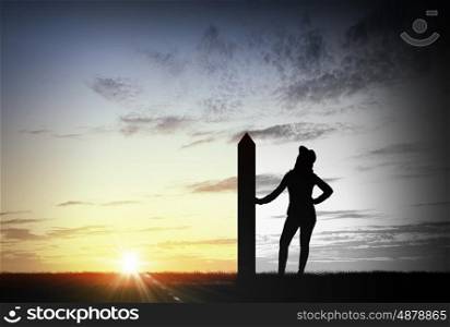 Reaching top of world. Silhouette of young woman with arrow banner on mountain top