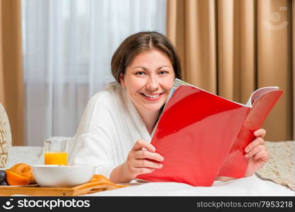 reading a magazine on the bed in the morning