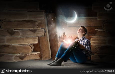 Reading and imagination. Teenager boy in jeans and shirt reading book