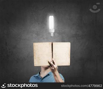 Reading book. Businessman with light bulb instead of head and with opened book in hands