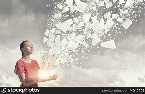 Reading books. Young girl with book in hands and pages flying in air