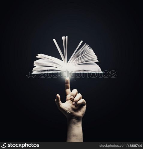 Reading concept. Close up of man hand pointing with finger at book