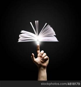 Reading concept. Close up of man hand pointing with finger at book