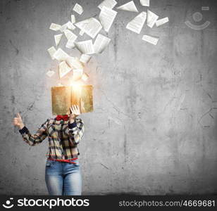 Reading concept. Woman in casual wear hiding her face behind book