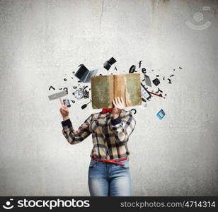 Reading concept. Woman in casual wear hiding her face behind book