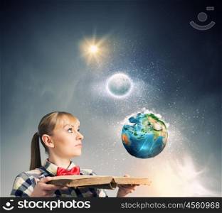 Reading concept. Woman in casual wear holding opened book in hands. Elements of this image are furnished by NASA