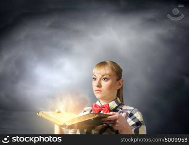 Reading concept. Woman in casual wear holding opened book in hands