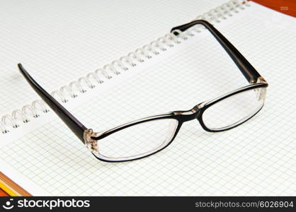 Reading glasses on the black page