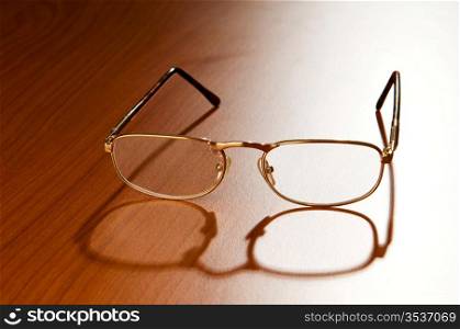 Reading glasses on the wooden background