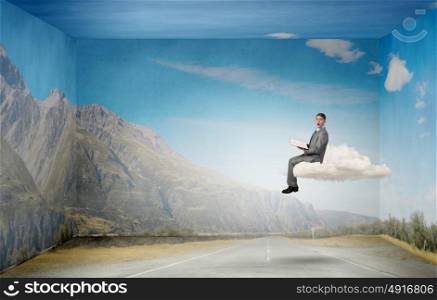 Reading in isolation. Young businessman floating on cloud with book in hands