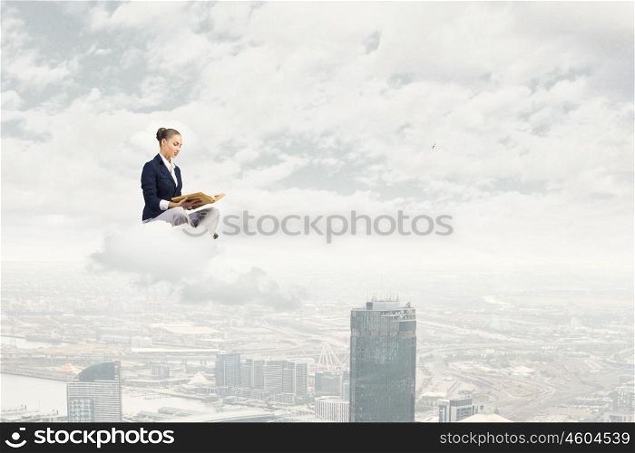 Reading woman. Young attractive woman sitting on cloud and reading book