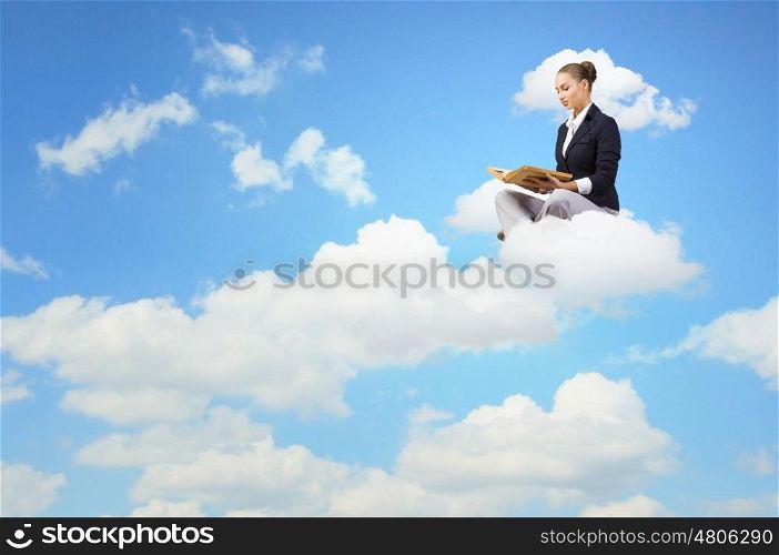 Reading woman. Young attractive woman sitting on cloud and reading book