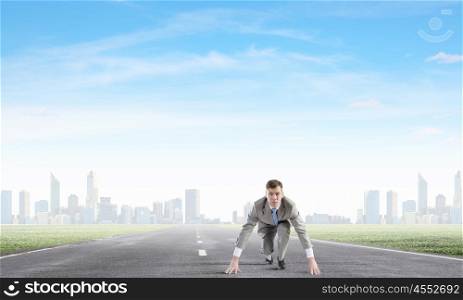 Ready to run. Young determined businessman standing in start position