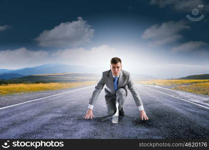 Ready to run. Young determined businessman standing in start position