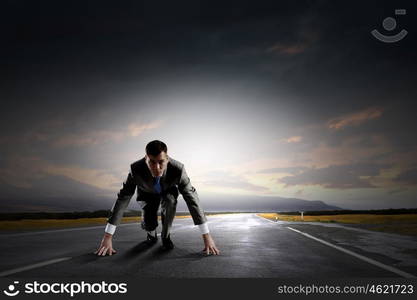 Ready to run. Young determined businessman standing in start position