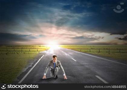 Ready to run. Young determined businessman standing in start position