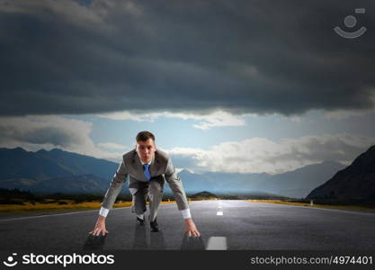 Ready to run. Young determined businessman standing in start position