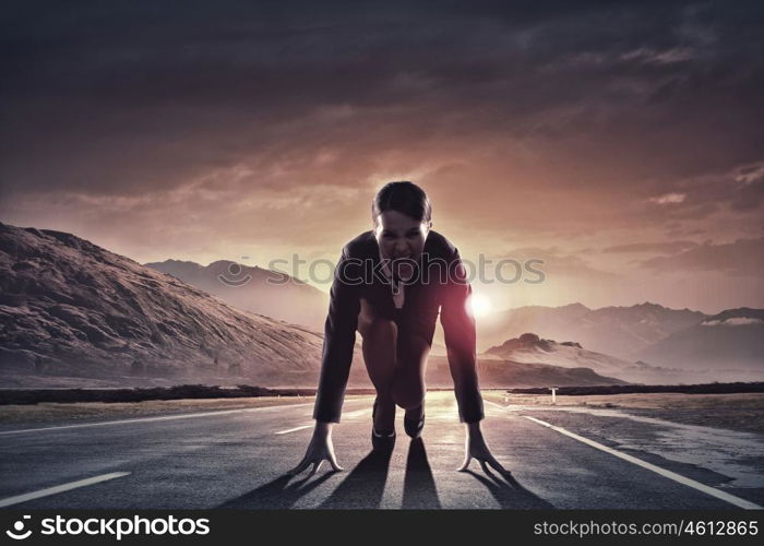 Ready to run. Young determined businesswoman standing in start position