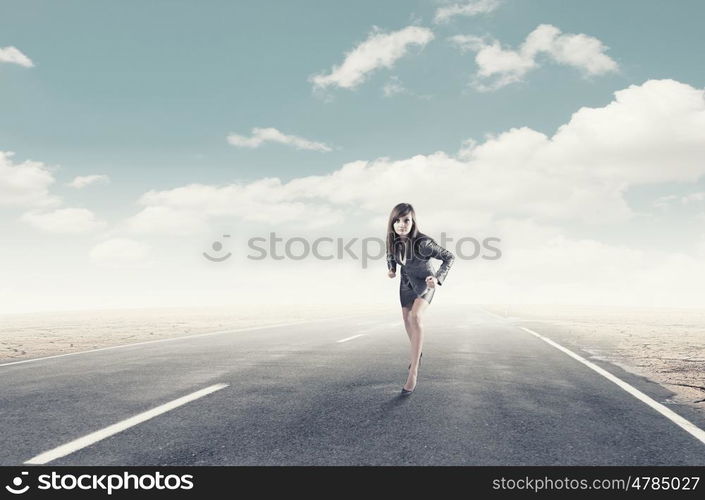 Ready to run. Young determined businesswoman standing in start position