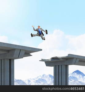 Ready to take a risk. Businessman jumping over a gap in the bridge as a symbol of bridge