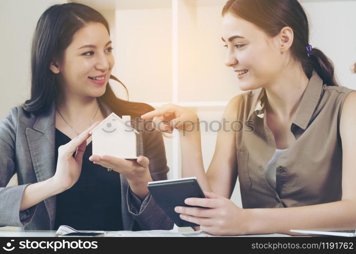 Real estate agent, financial adviser or insurance sales person is talking about house buying, mortgage loan or insurance protection to her client in the office.