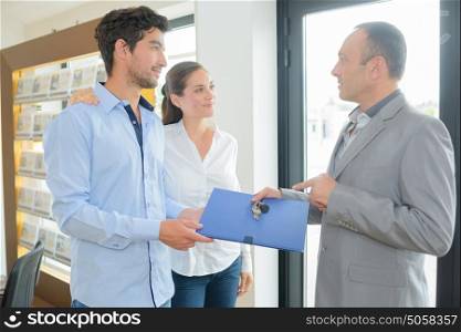 real estate agent giving folder to future home owners
