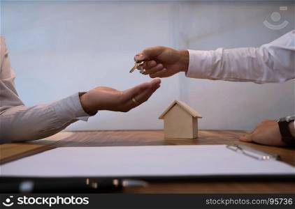 Real estate agent giving keys to customer after contract signature