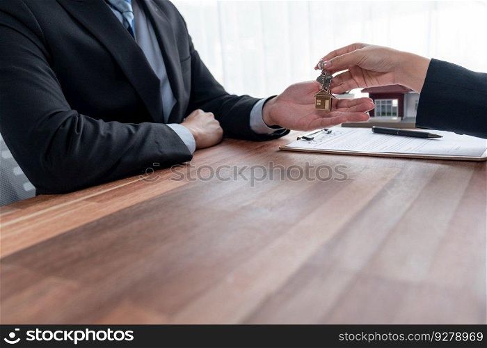 Real estate agent handing house key to buyer after successful signing house loan contract. Landlord hand over house key to client. Entity. Real estate agent handing house key to buyer. Entity