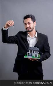 Real estate agent hold house model s&le with a key on isolated background. Housing business with copyspace. Realtor presenting key property investment opportunity on house loan idea. Fervent. Real estate agent hold house model and key on isolated background. Fervent
