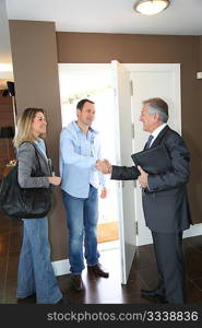 Real estate agent showing modern house to couple