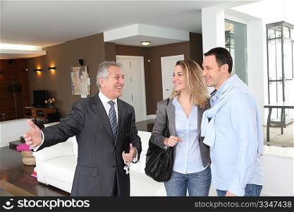 Real estate agent showing modern house to couple