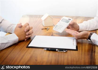 Real estate agent showing the purchase price on a calculator to customer